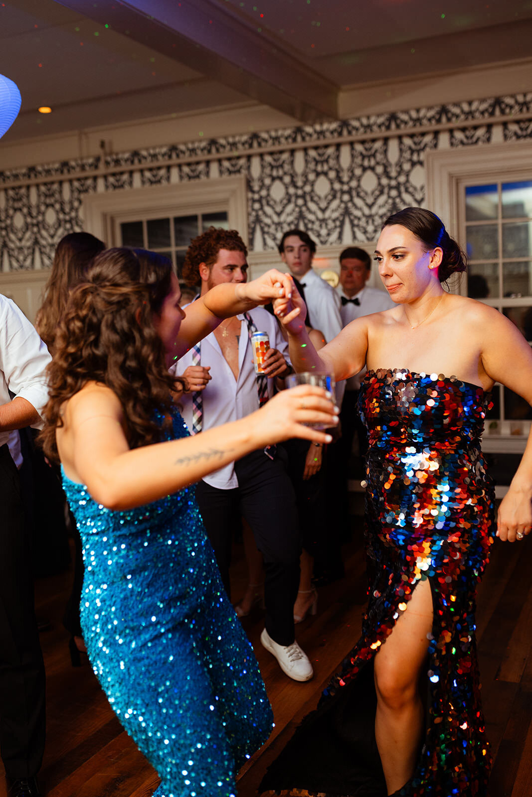 Brides in sparkly dresses with drinks in hand