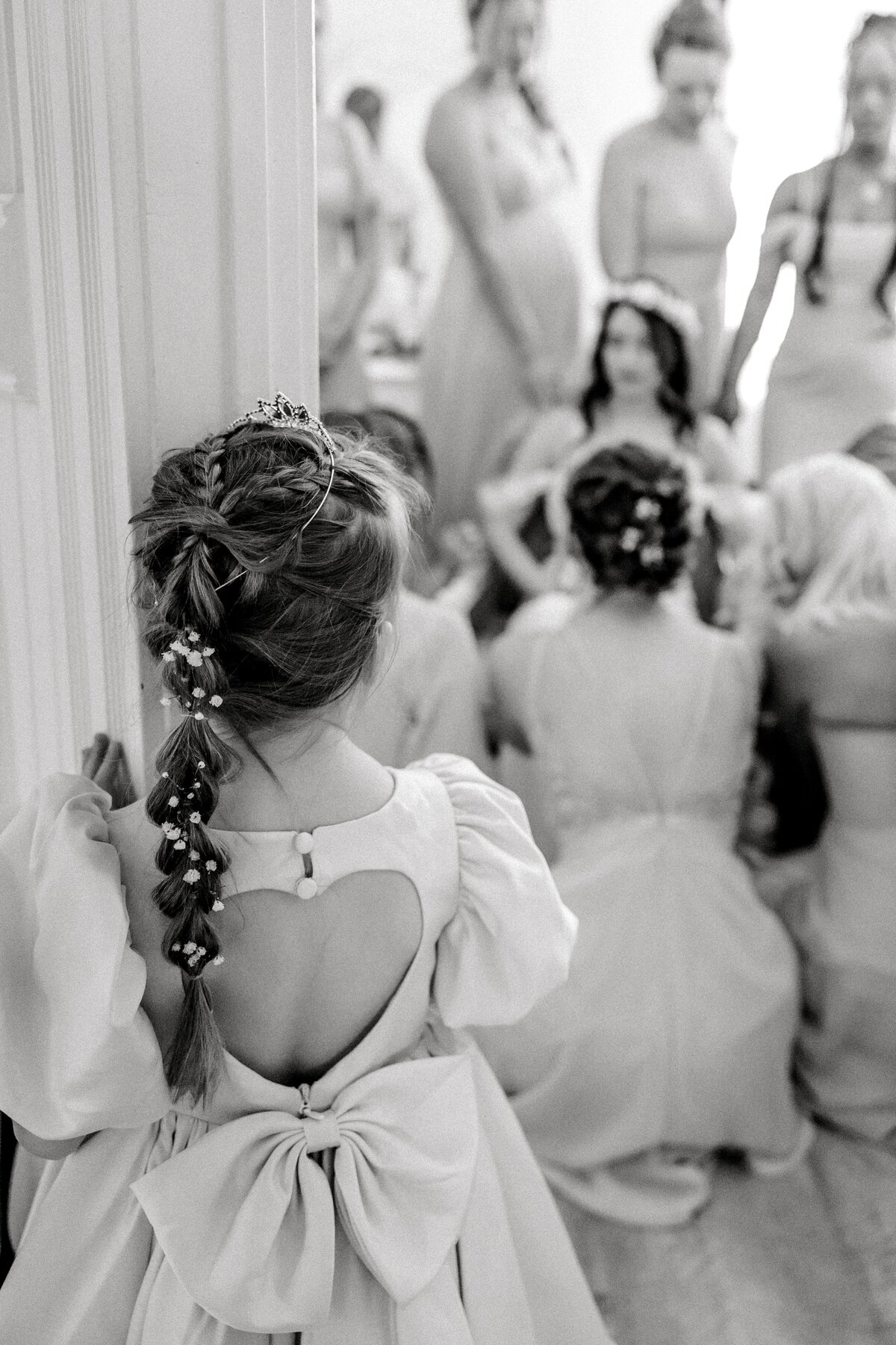 Flower girls peers in through the door at a moment where the bridesmaids are praying for the bride before she walks down the aisle of her Spokane wedding day at Belle gardens