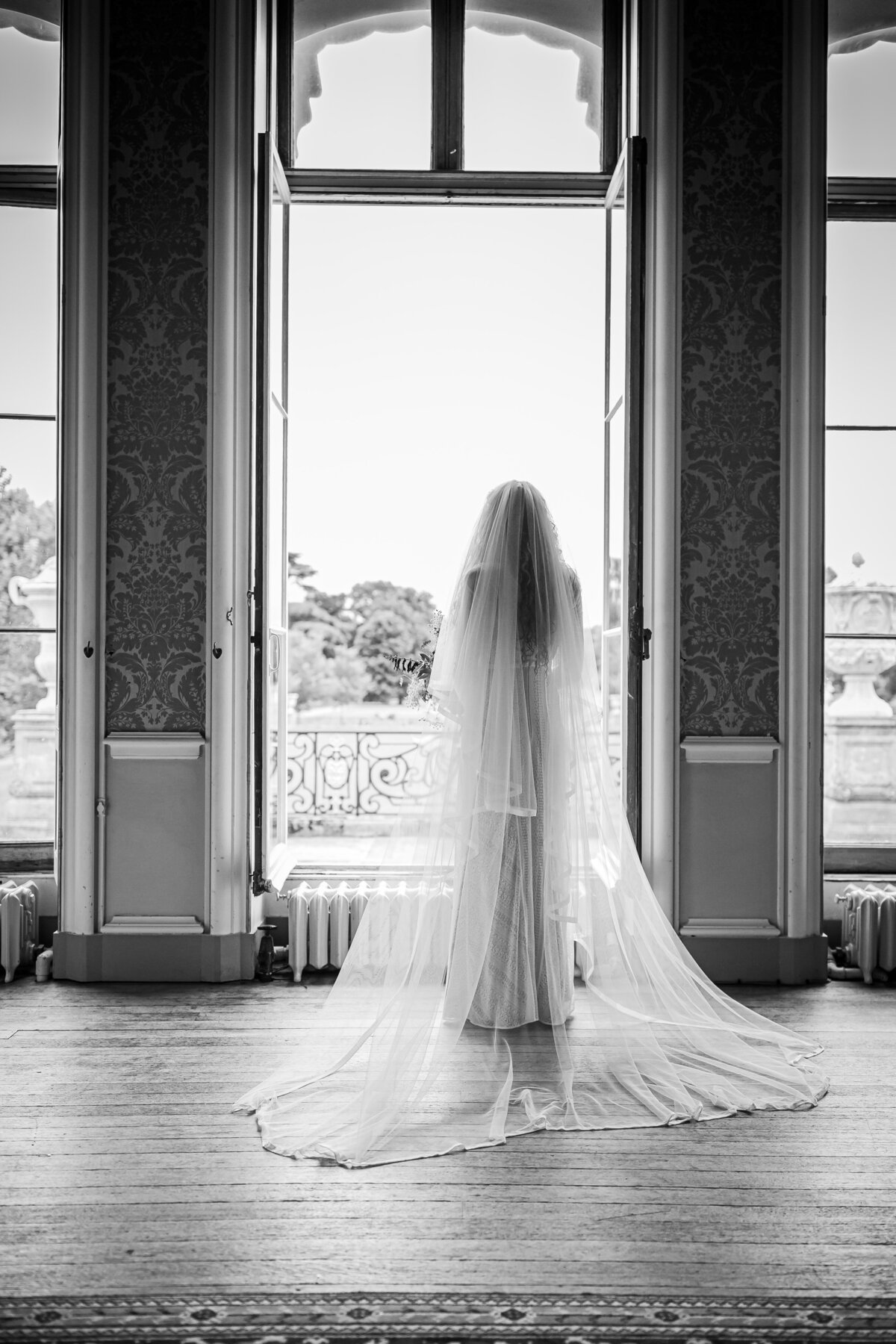 Bride stood by the window in her wedding dress