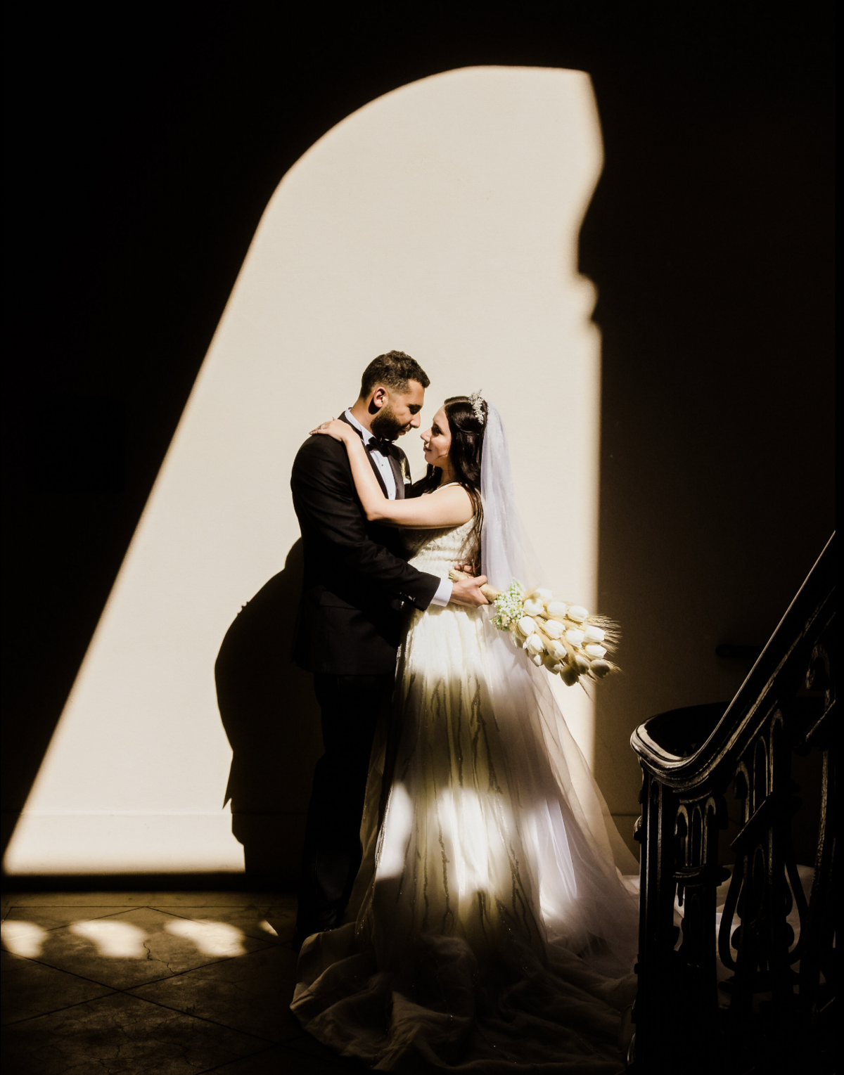 Bride and groom dancing in the shadows