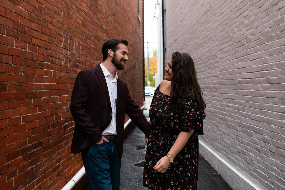 Couple walks and laughs during their engagement session