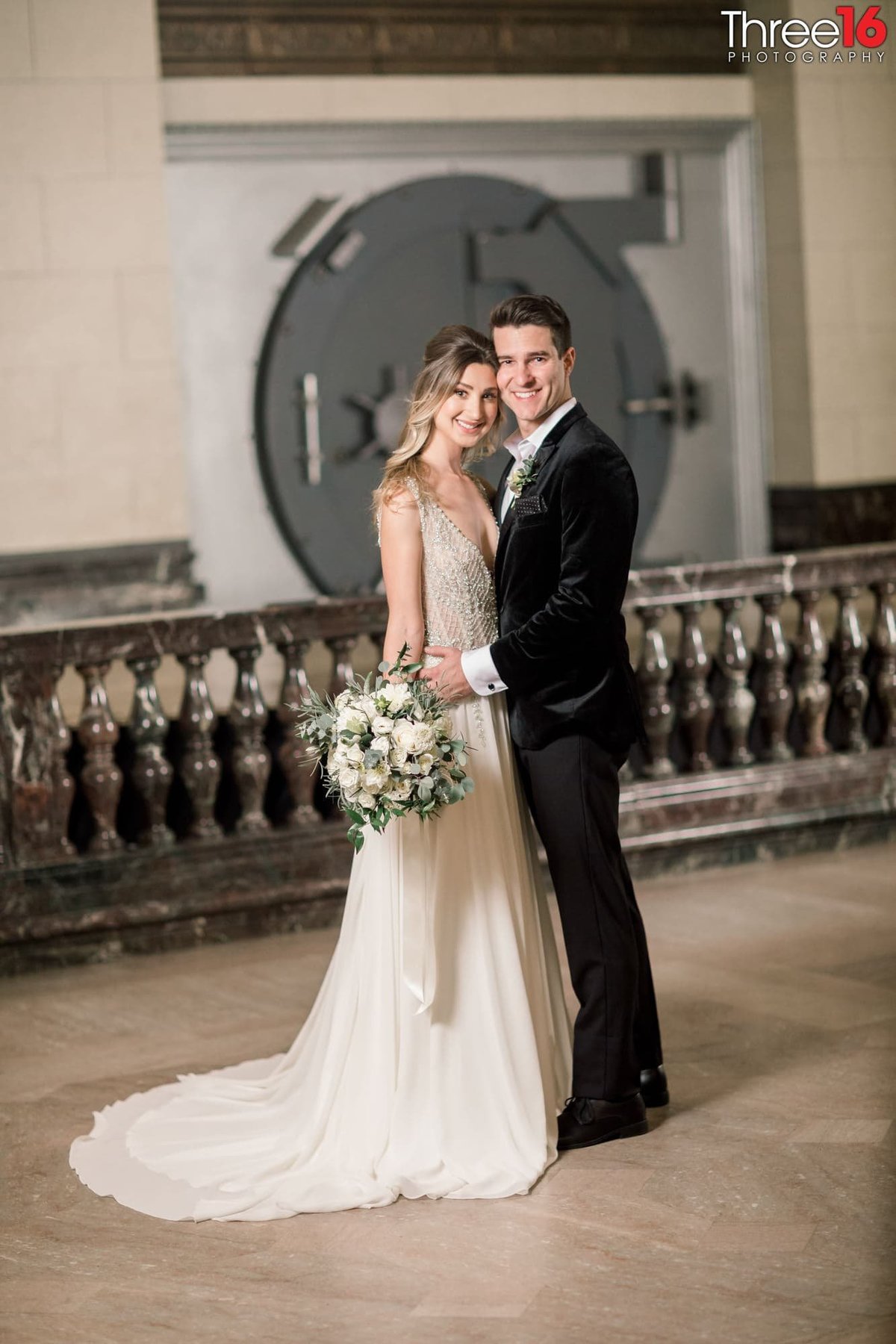 Bride and Groom pose in front of an old vintage vault