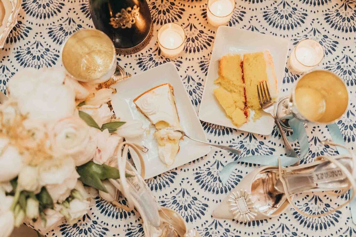 flat lay of party night at reception including cake, drinks, shoes, and candles