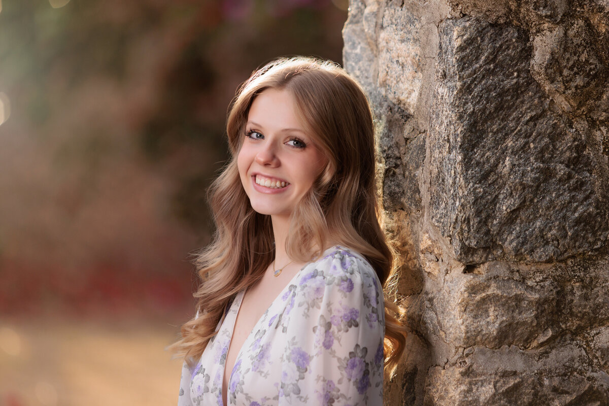 Holly Springs Teen Portraits in Raleigh NC leaning against a rock column.
