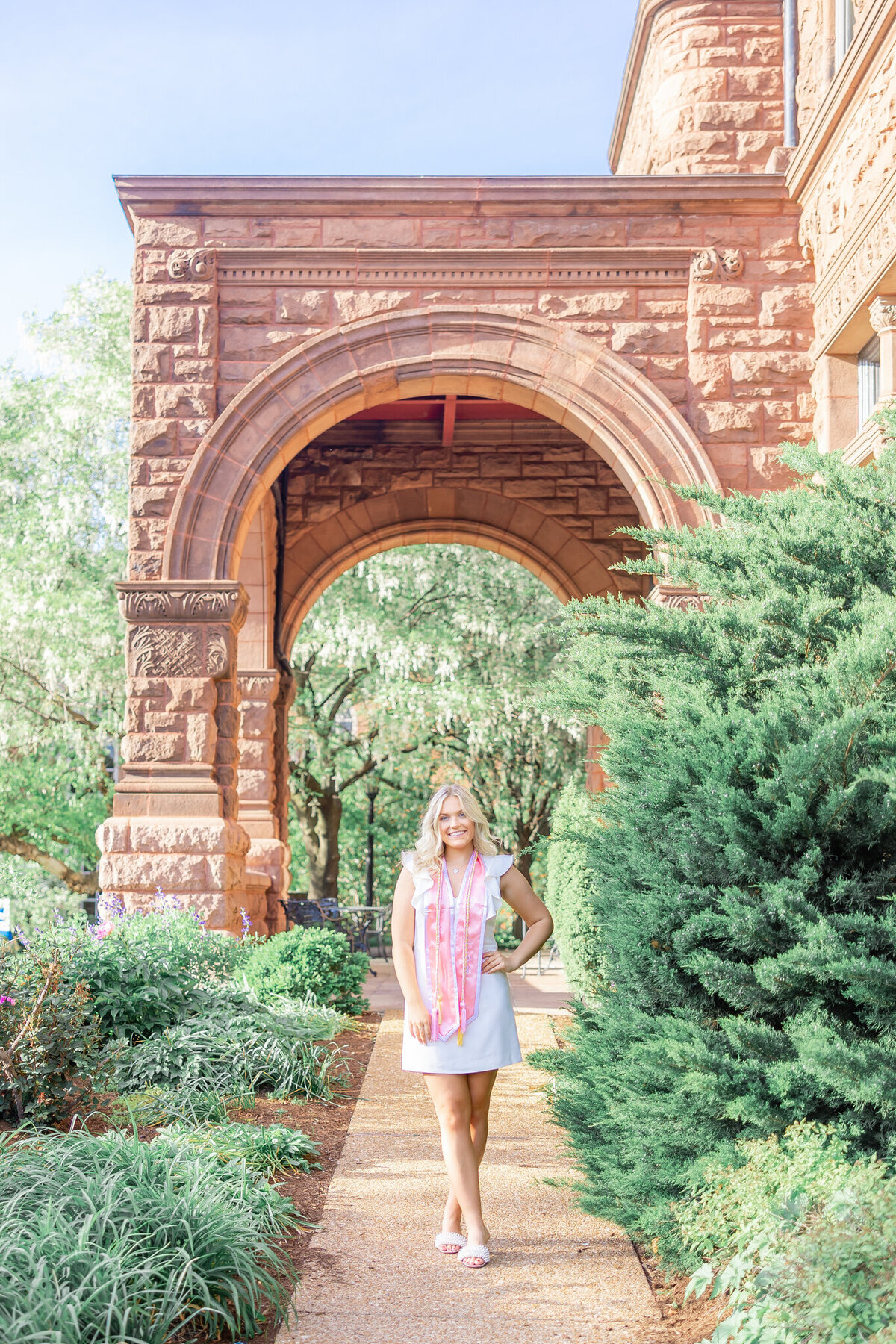 blonde senior girl in archway in front of cupples house on SLU's campus