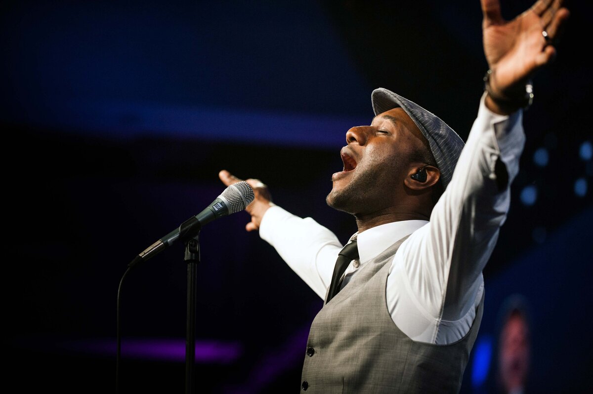 Aloe Blacc sings at event in Las Vegas with hands stretched out wide
