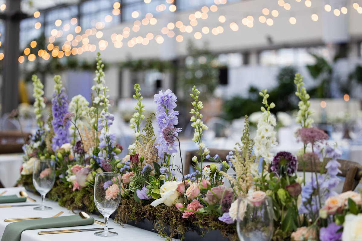 Floral centrepieces with purple and sage tones for this garden themed wedding reception.