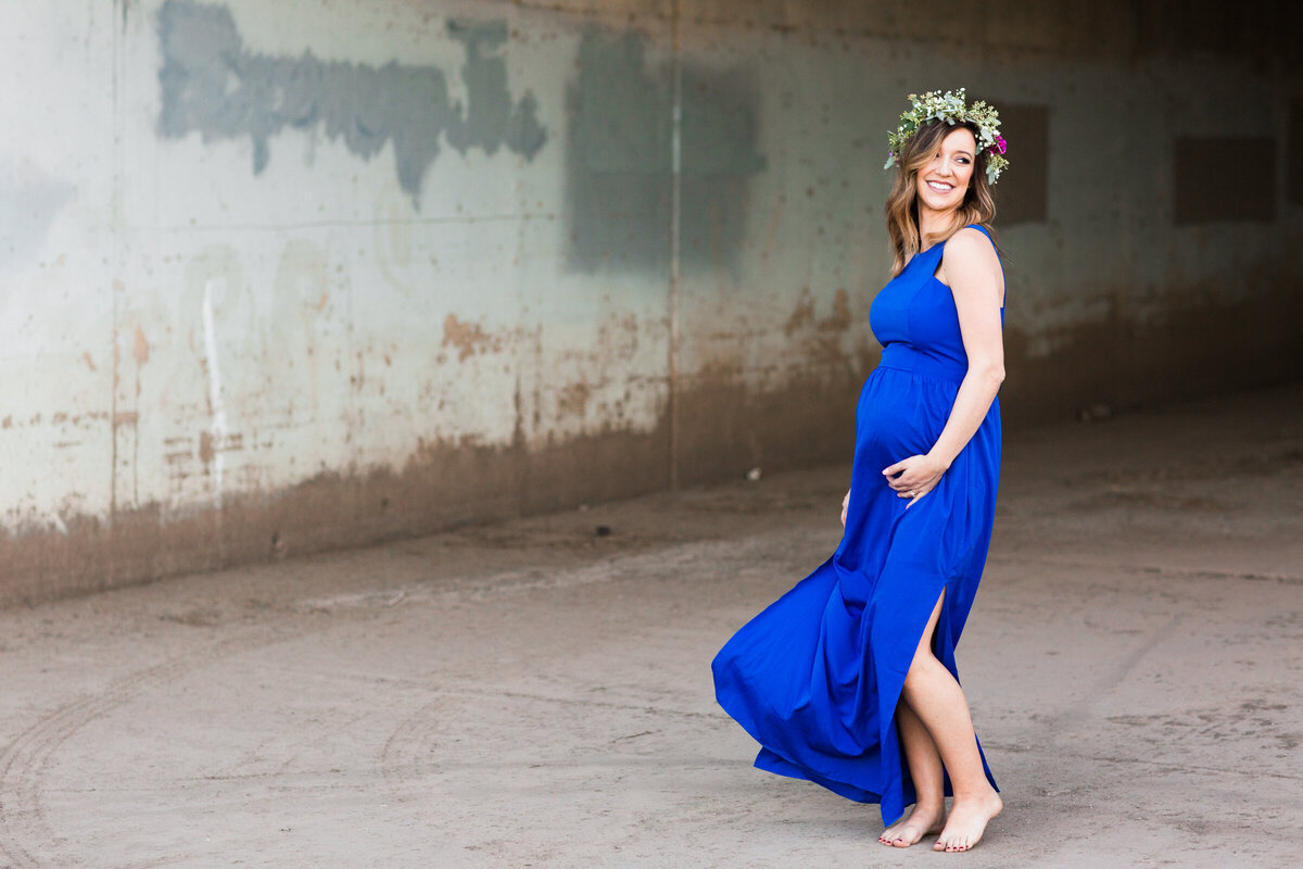 mom to me in long dress holding baby bump