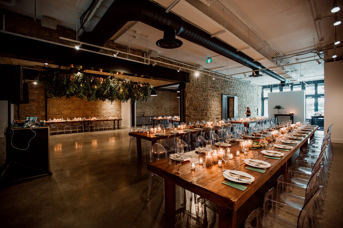 Elegant and moody indoor reception at The Pioneer, a historical industrial wedding venue in Calgary, featured on the Brontë Bride Vendor Guide.