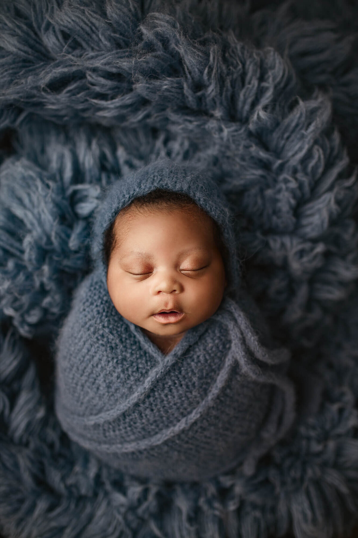 baby swaddled in blue wrap