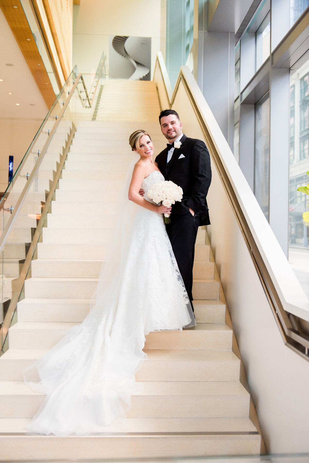 bride and groom smiling at the camera on fairmont hotel steps