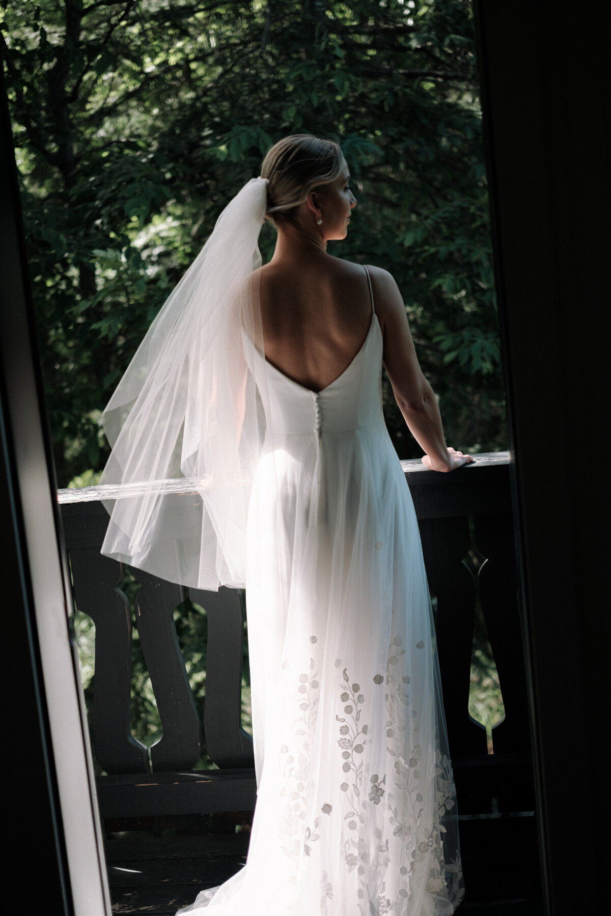 Stunning woman at her wedding overlooking nature on the balcony before her ceremony