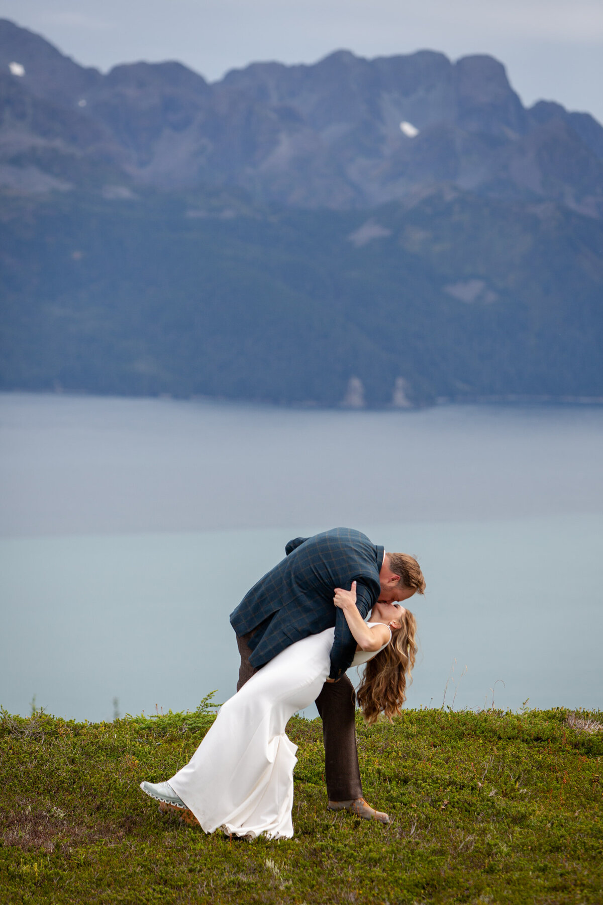 A groom dips his bride with a big kiss.