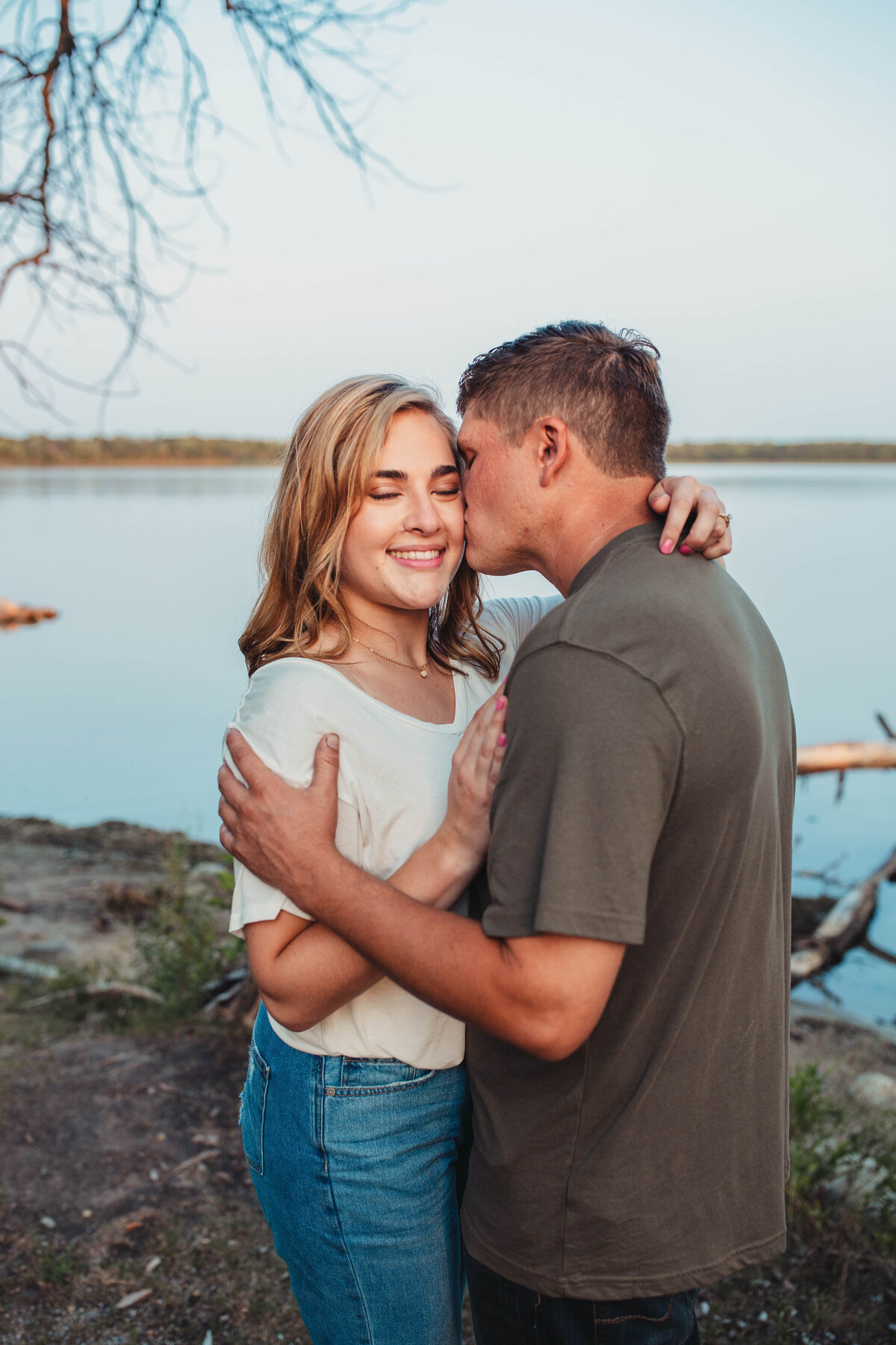 engaged-couple-kissing-by-lake