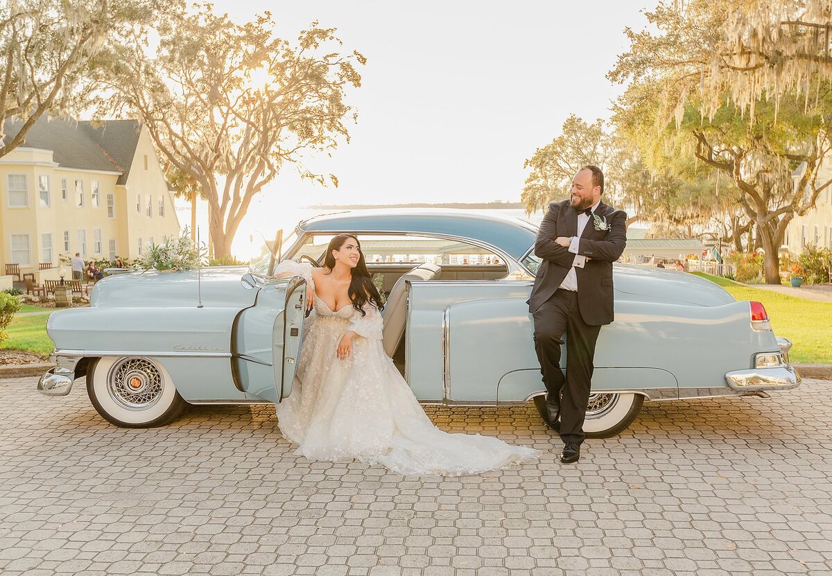 bride and groom pose at vintage car Lakeside Inn