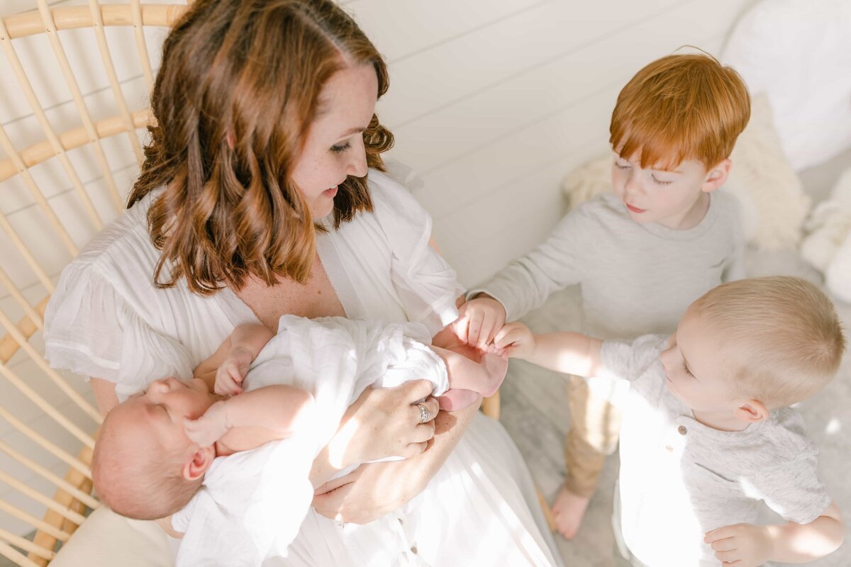 Orange County Newborn Photographer - mom of three boys in a cocoon chair
