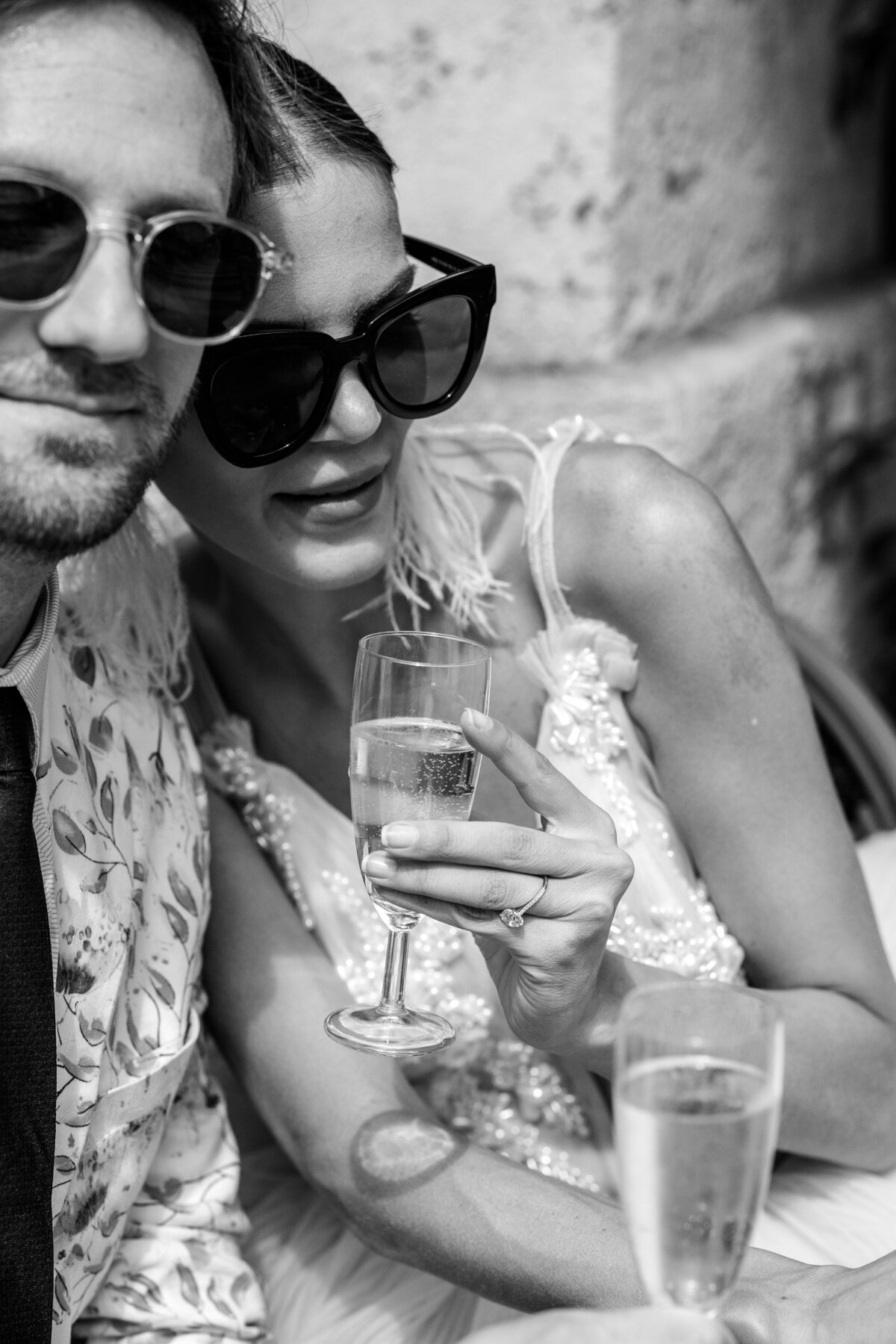 Black and white of couple  drinking champagne during their Paris engagement session, photographed by Italy wedding photographer.