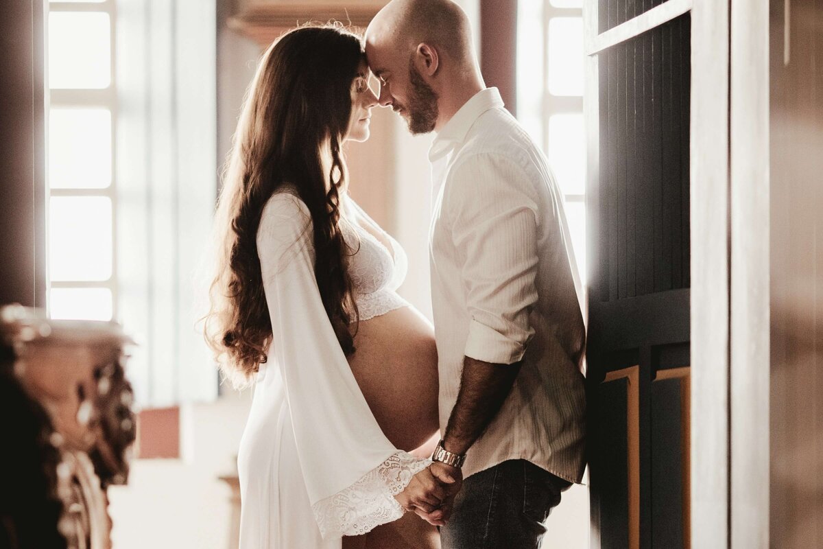 Man Wearing White Dress Shirt Holding Hands With Woman Wearing White Robe