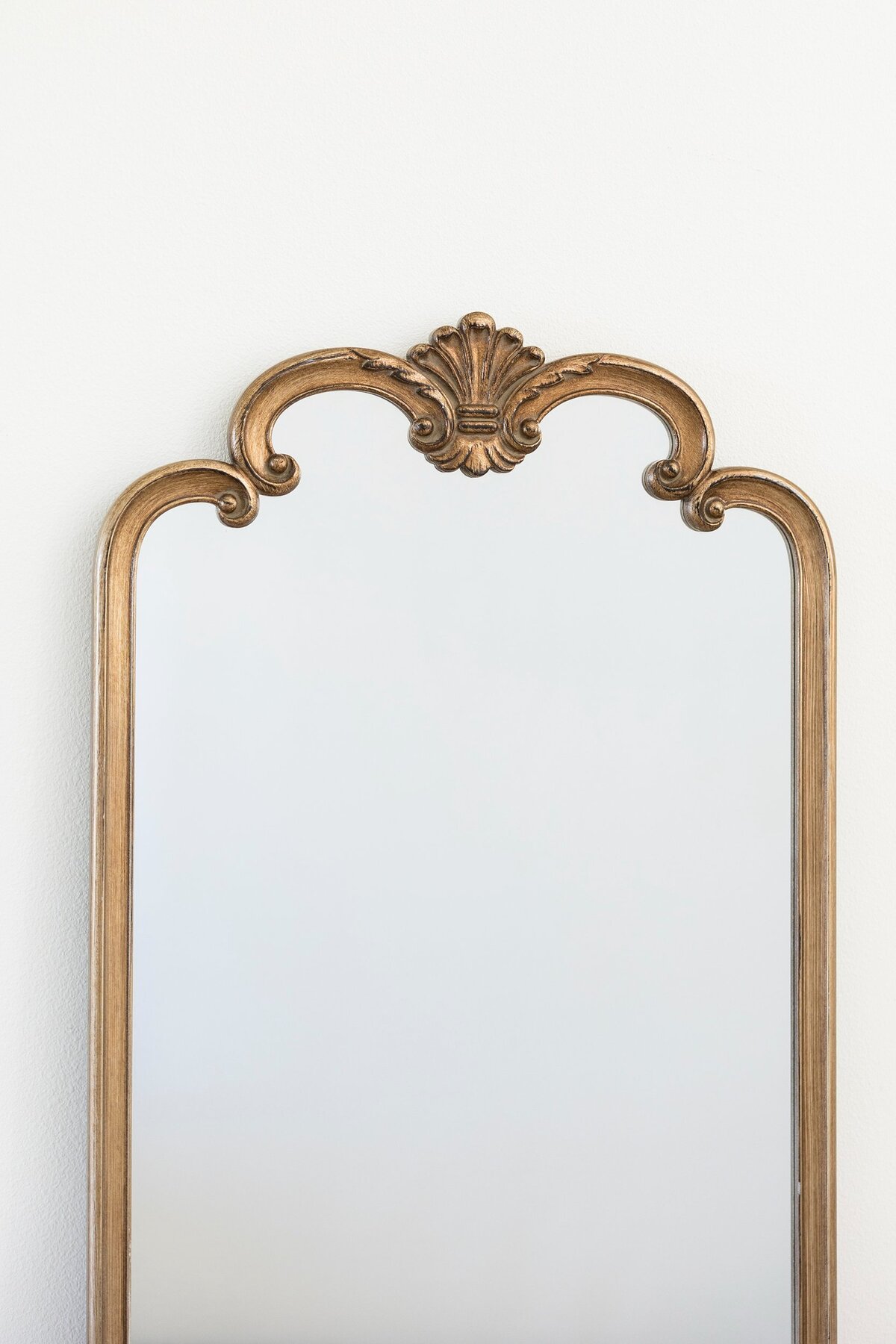 Large gold wood mirror with ornate arches at the top 