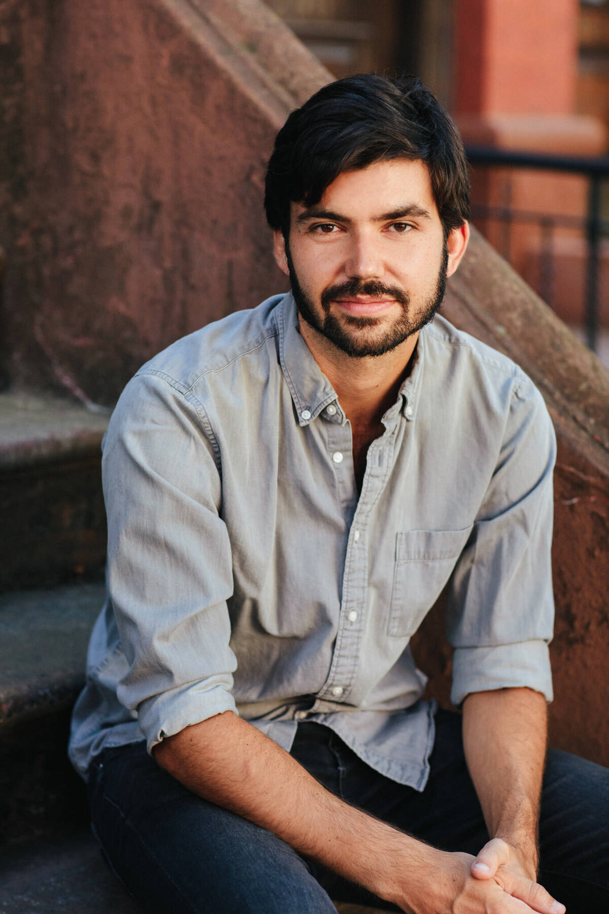 portrait of author and editor daniel loedel sitting on a stoop in brooklyn