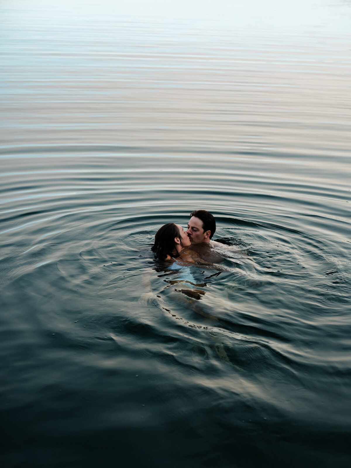 Bride and groom kissing in a lake  in Idaho