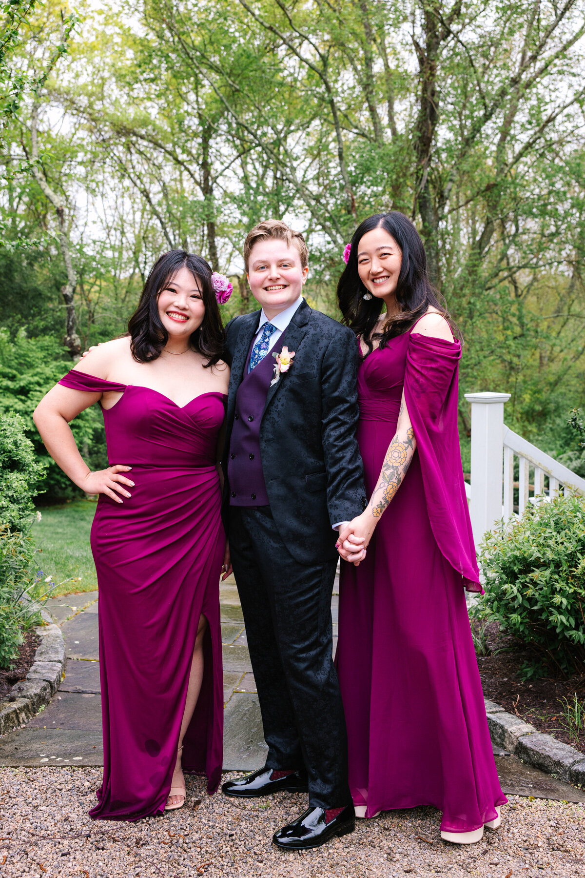Bride in suit with two bridesmaids on their side