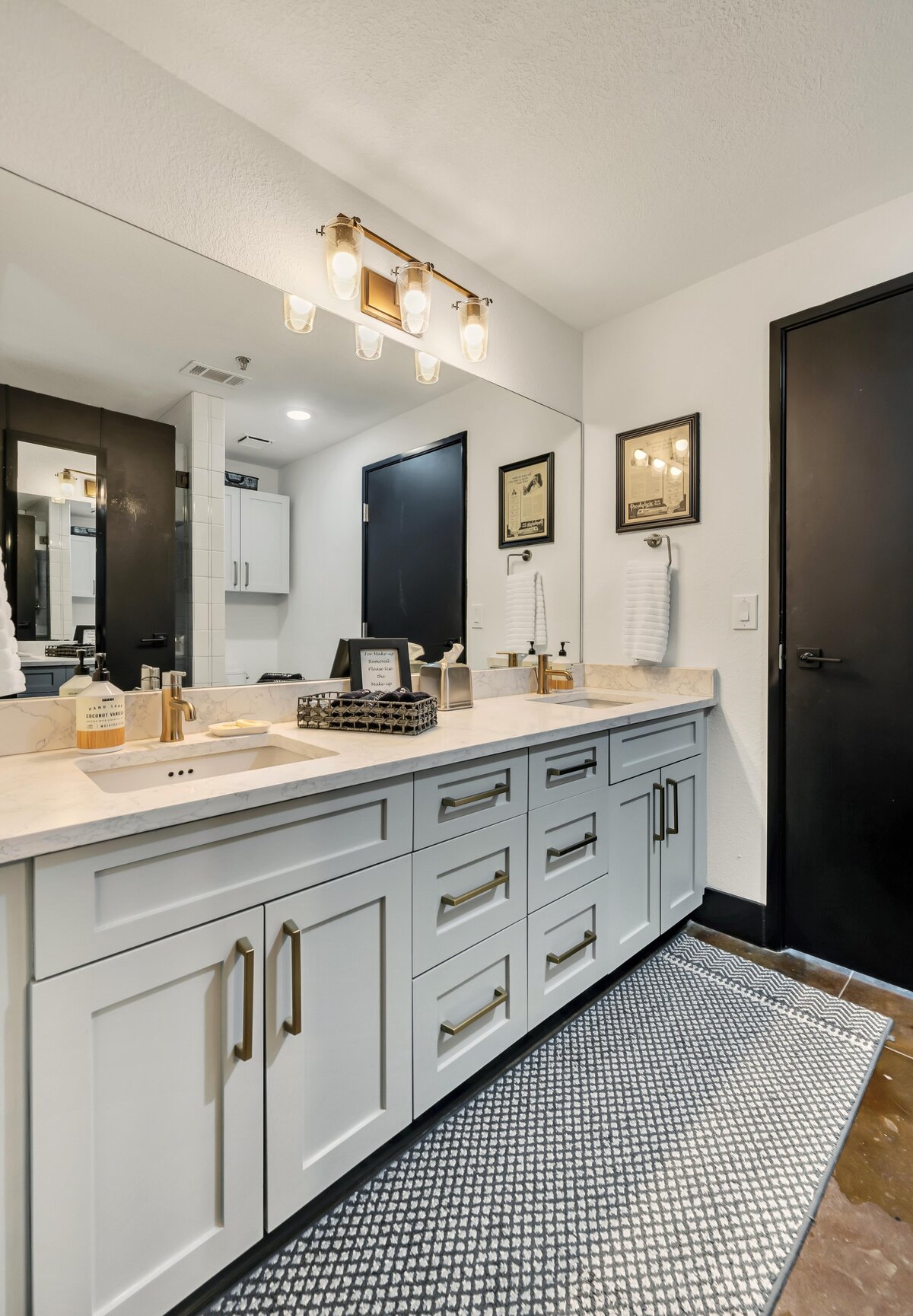 Bathroom with double vanity in this three-bedroom, two-bathroom industrial vacation rental loft with free WiFi, skyline view, and fully stocked kitchen in downtown Waco, Tx