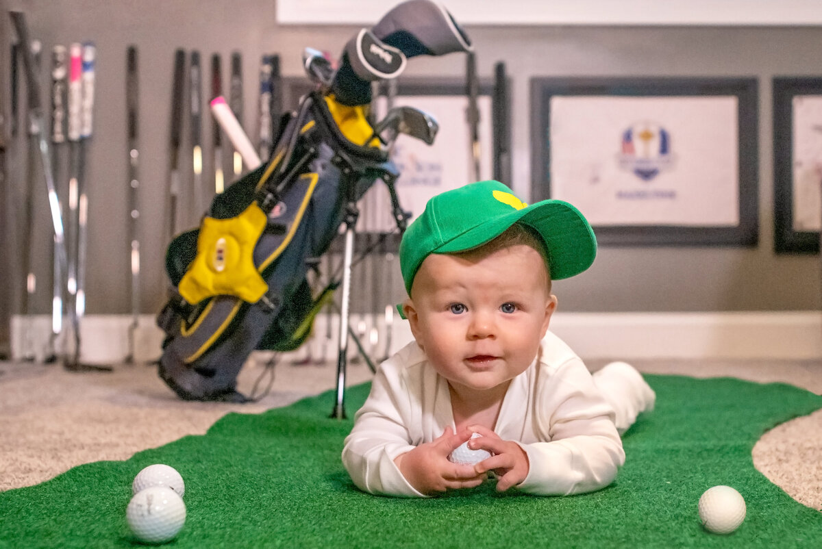 Baby with  golf balls and clubs