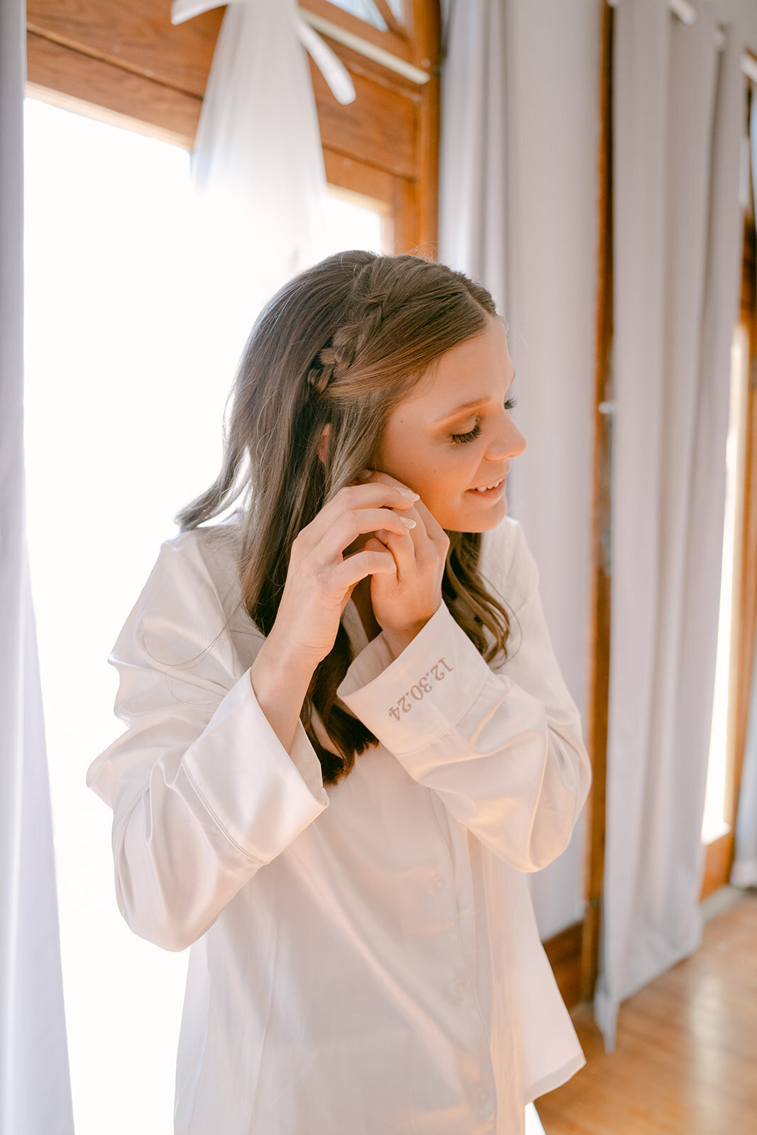 Bride putting on bridal earrings during a quiet, elegant getting ready moment in San Antonio bridal suite