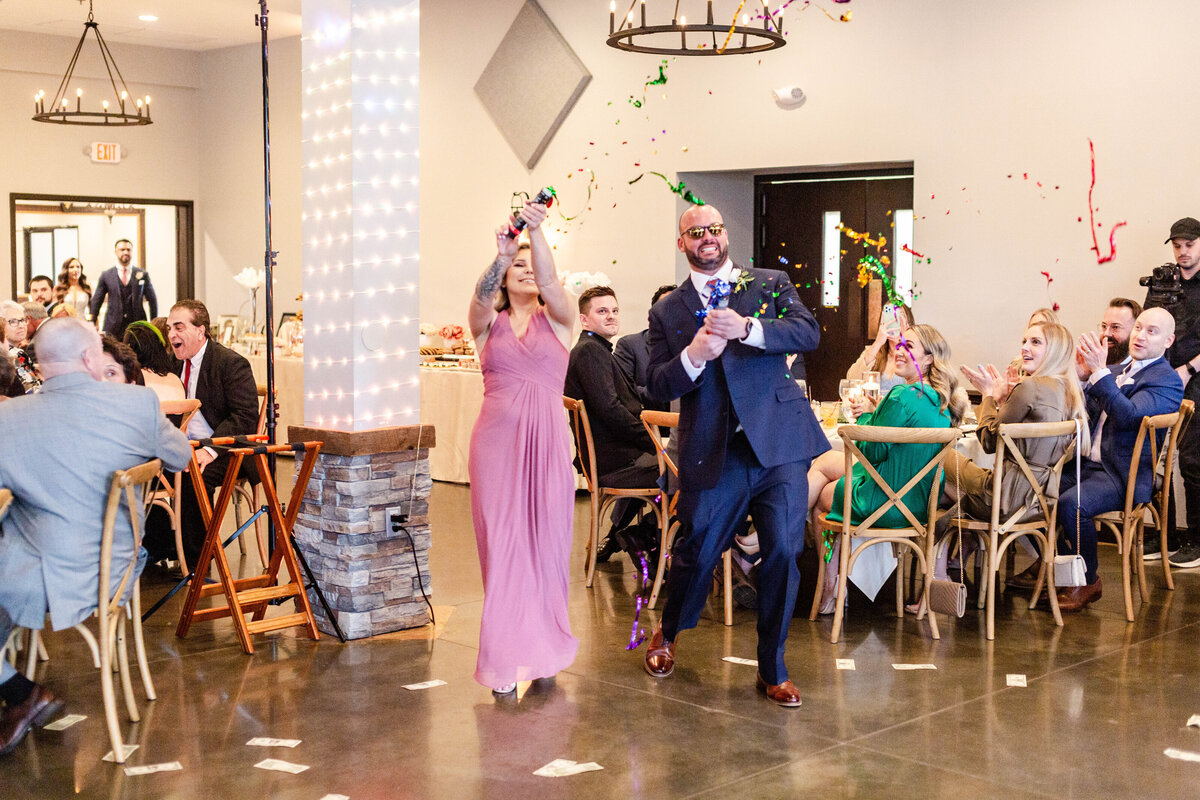 Vibrant confetti entrance captured by Style & Grace Photography at Piazza Messina in Cottleville, MO, as the newlyweds make a grand and colorful entrance into their wedding reception.