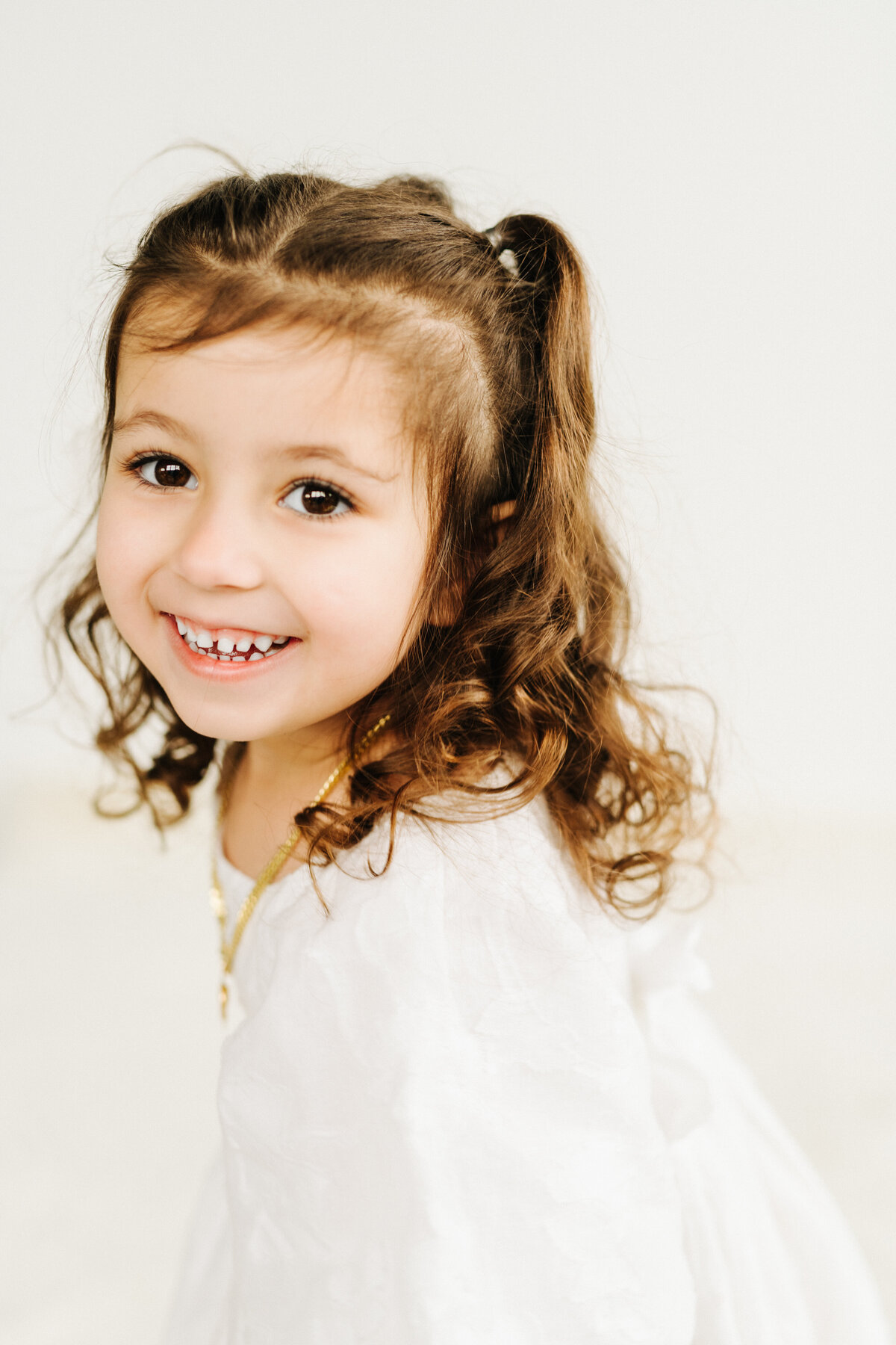 smiling little girl with curly brown hair