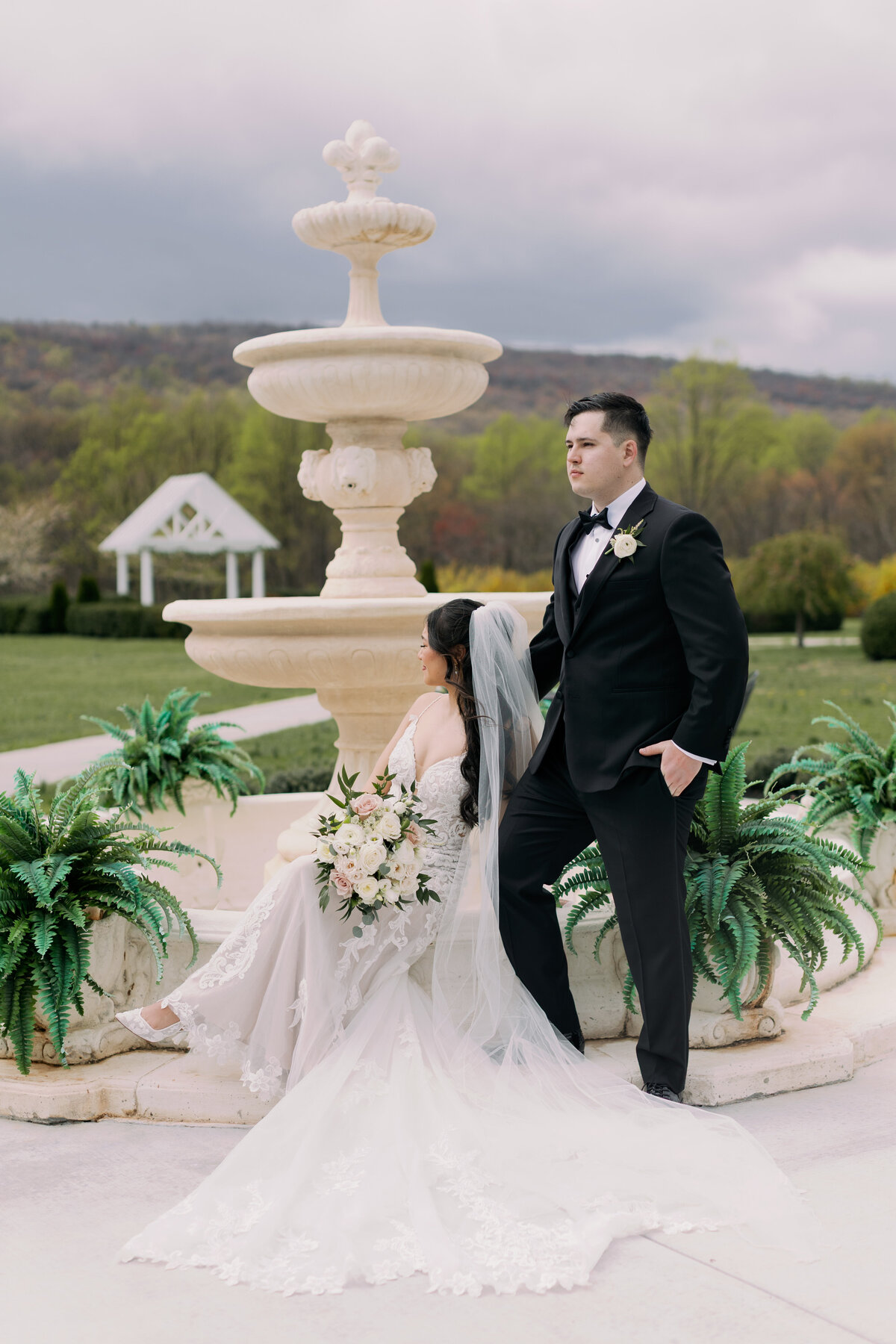 Bride and Groom pose for their bridal portraits by a fountain