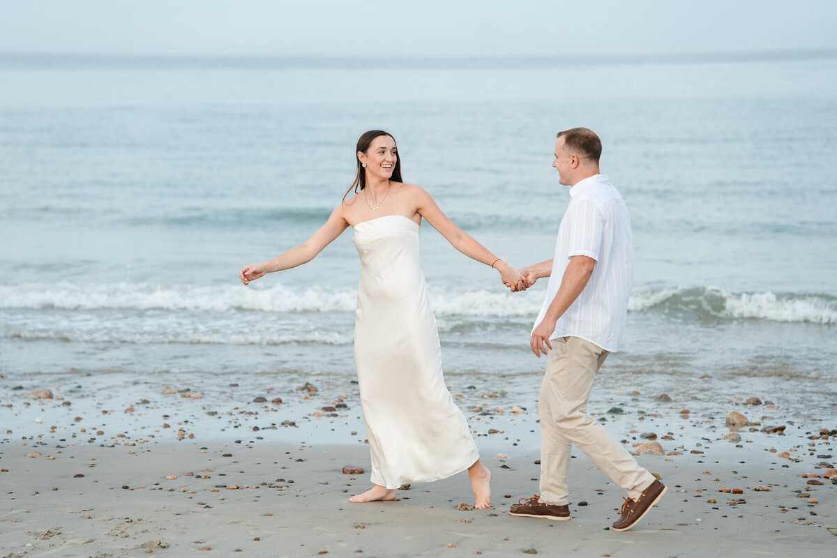 New England beach engagement photos during a sunset coastal session with candid moments.