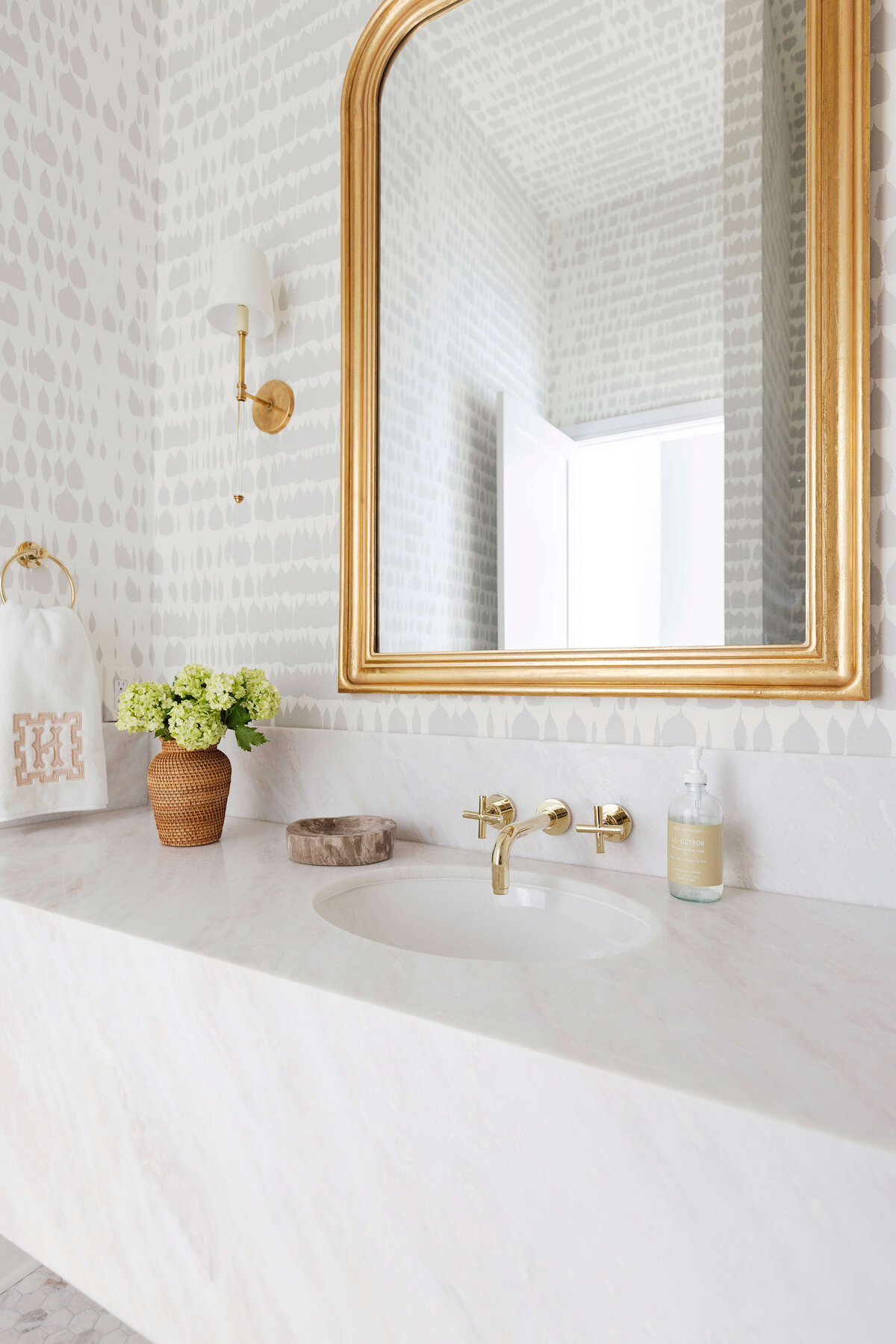 oyster creek studios hughes marble vanity with gold mirror in bathroom