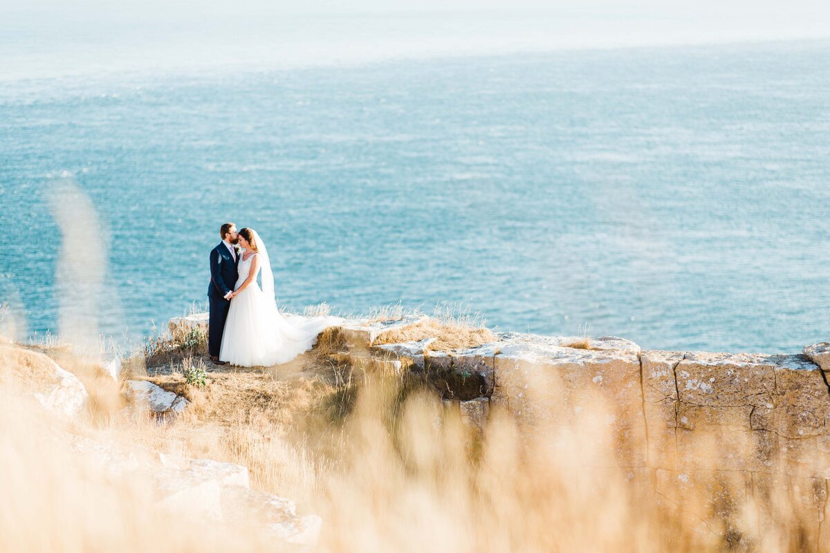 Bride and Groom clifftop portrait overlooking the sea  at the Jurassic Coast.
