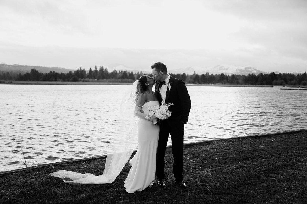 Bride Jenay holding a bridal bouquet with white blooms and ruffled garden roses in mauve and sand tones, designed by Summer Robbins Flowers in Central Oregon