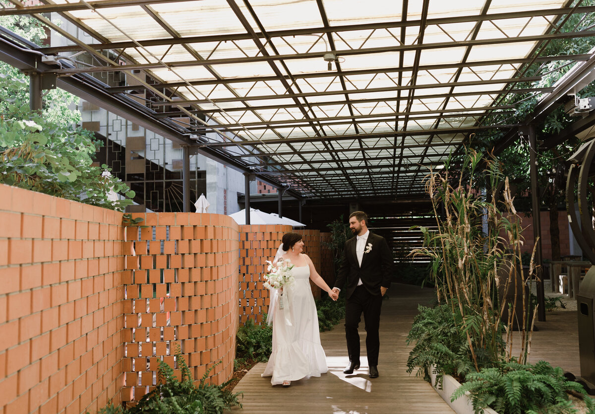 Bride and groom walking through atrium at Umlauf Sculpture Garden, Austin