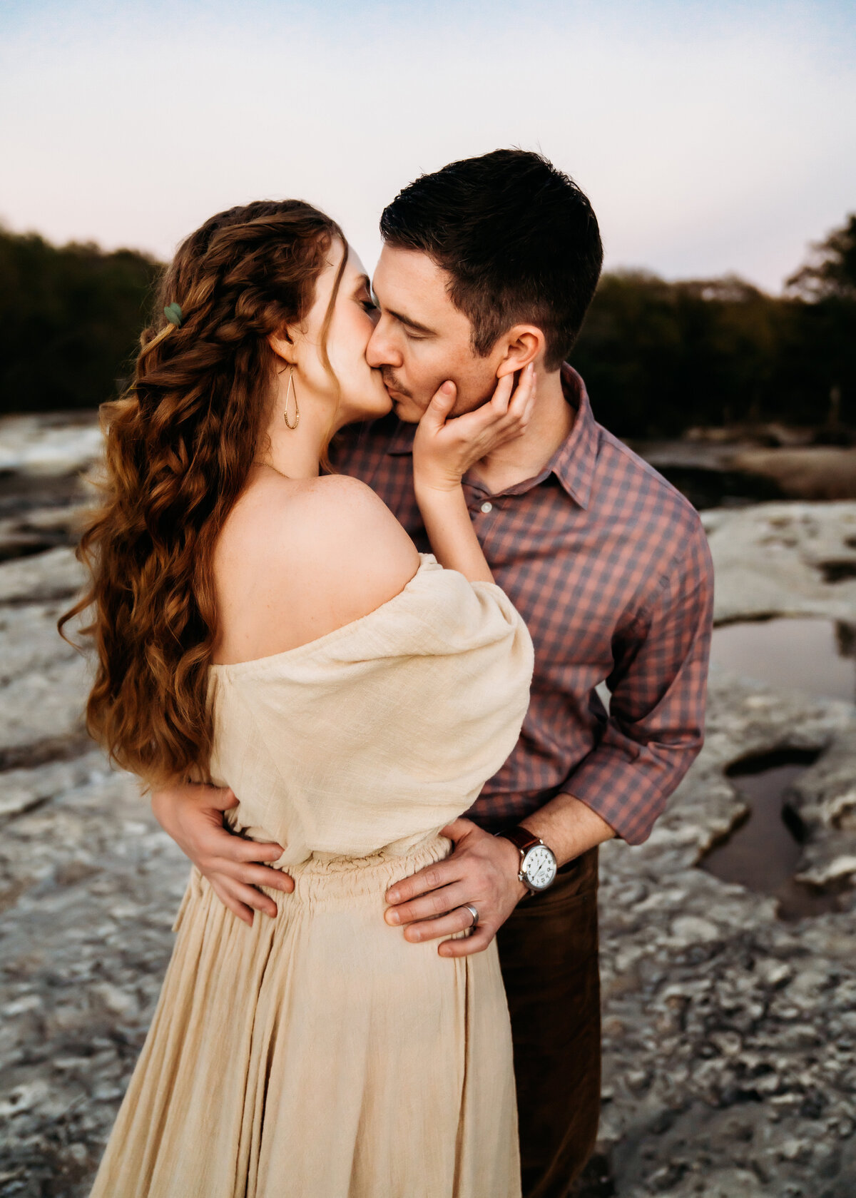 Family Photographer, a couple kiss as they stand rocks among the waters