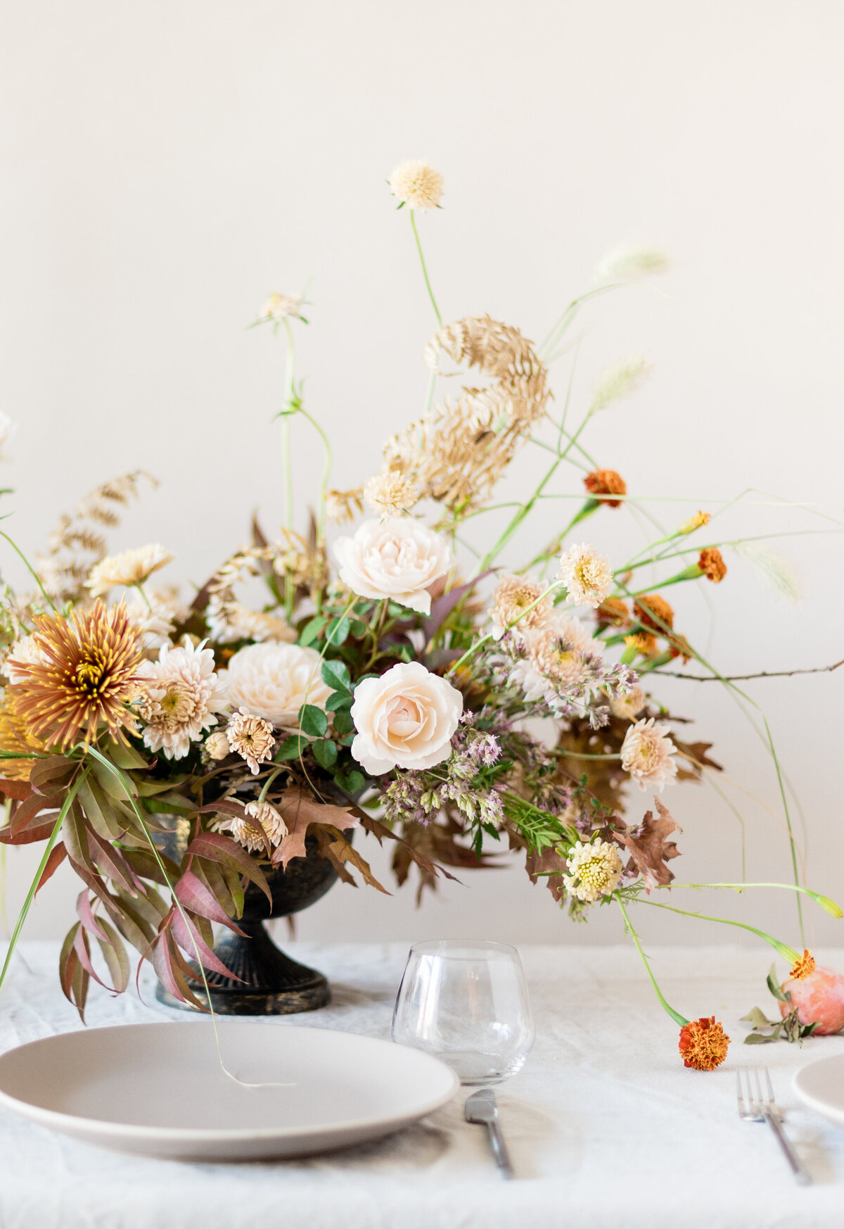 An airy garden centrepiece with pink and orange flowers at a Montreal wedding reception.