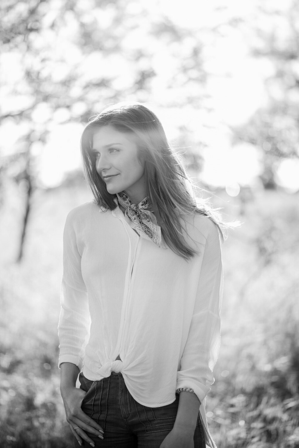 dreamy portrait of a young woman standing in a field as the wind gently blows around her.