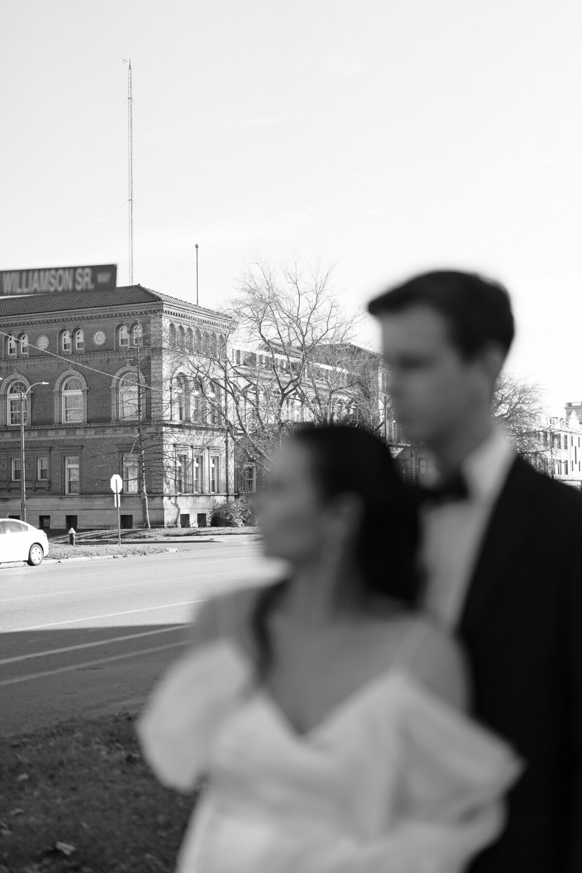 Couple photographed out of focus in front of historic downtown architecture