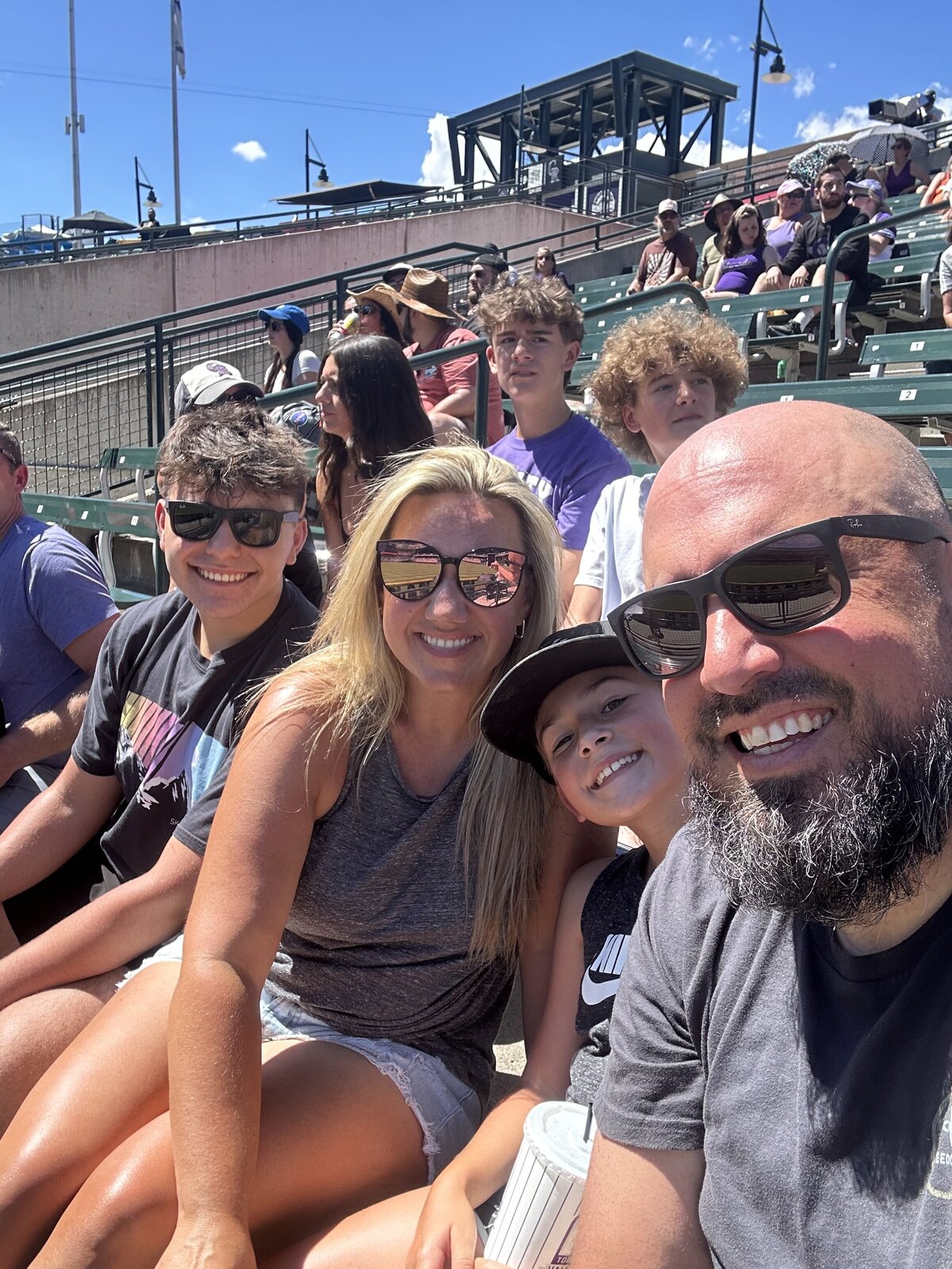 family of four pose for a selfie at a Colorado Rockies game