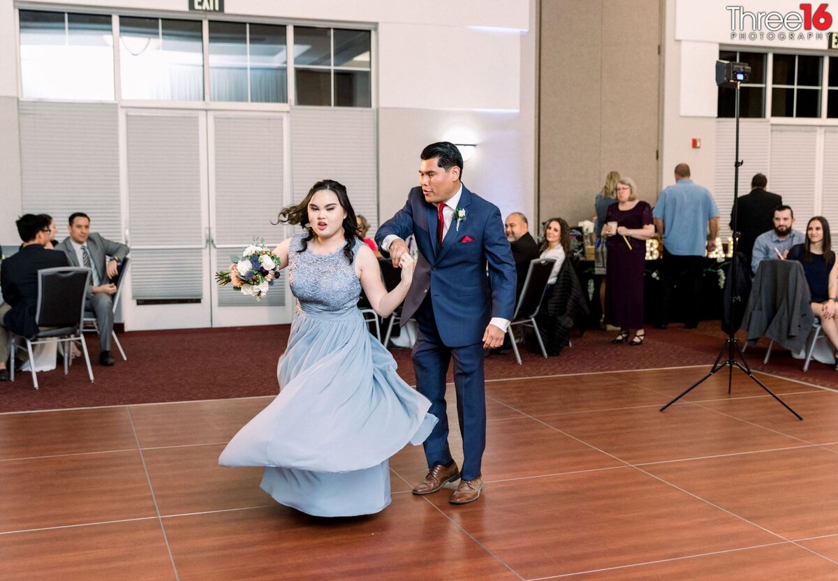 Groomsman spins a Bridesmaid on the dance floor