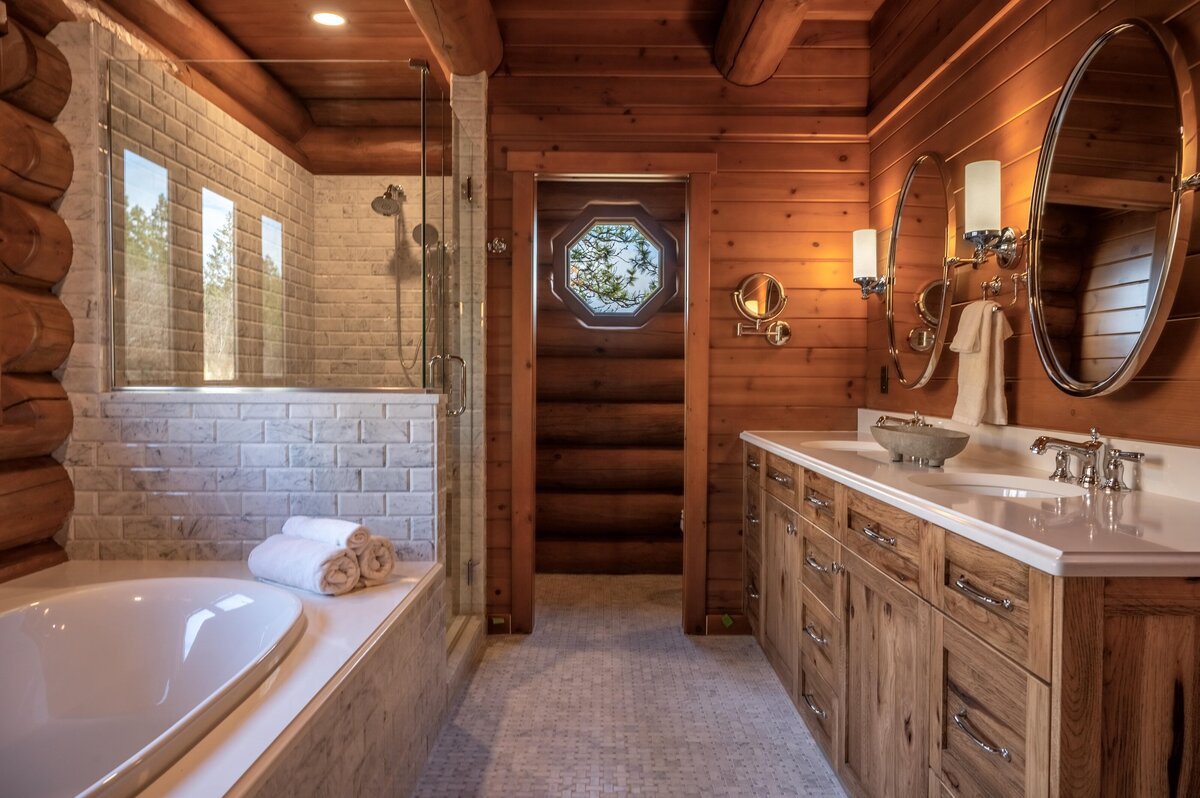 Rustic bathroom with wood accents, a large soaking tub, and double vanity, Photo by Moore Creative.