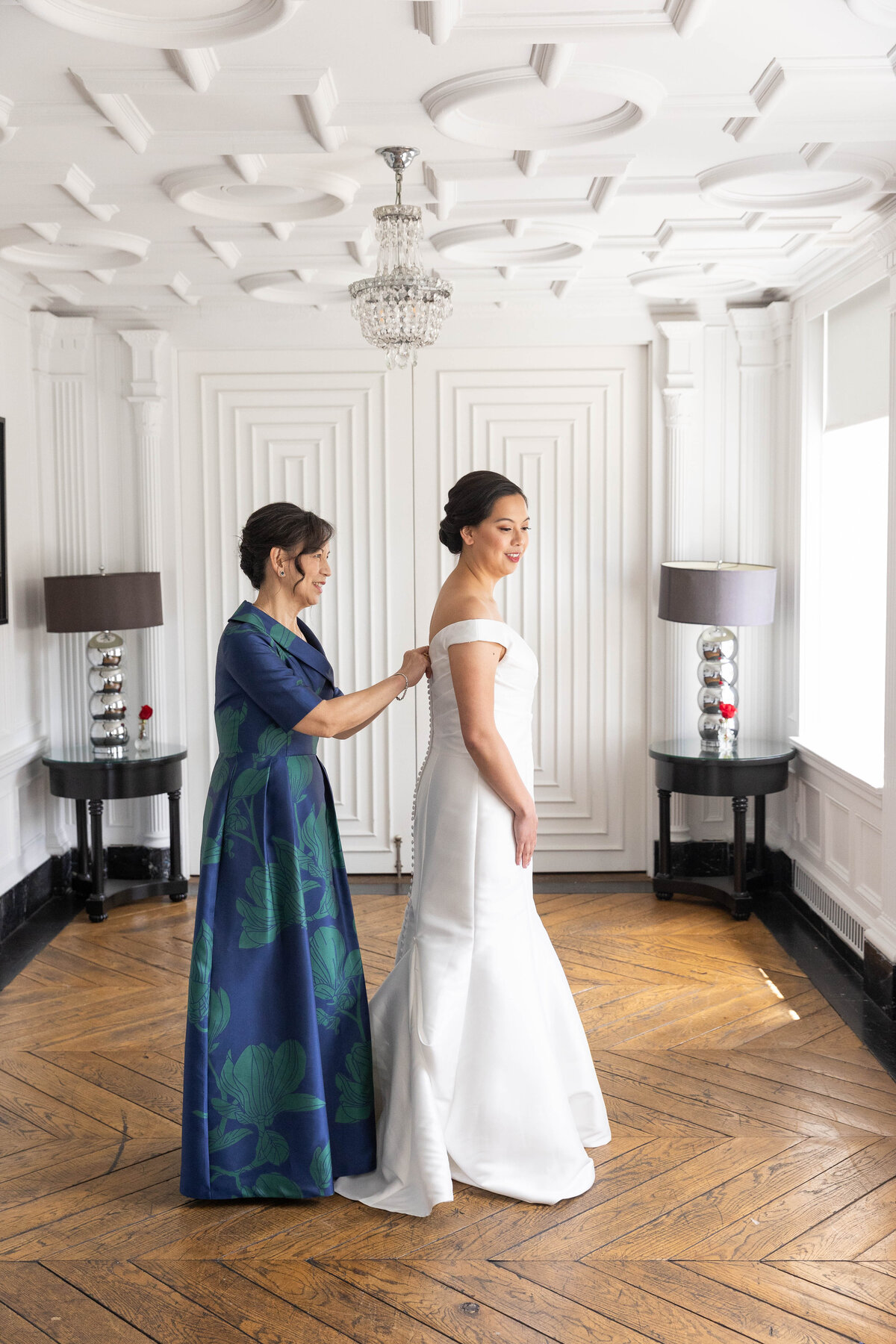 Mother of a bride helping her get dress