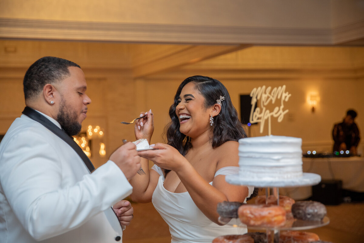 Bride feeding her groom the wedding cake