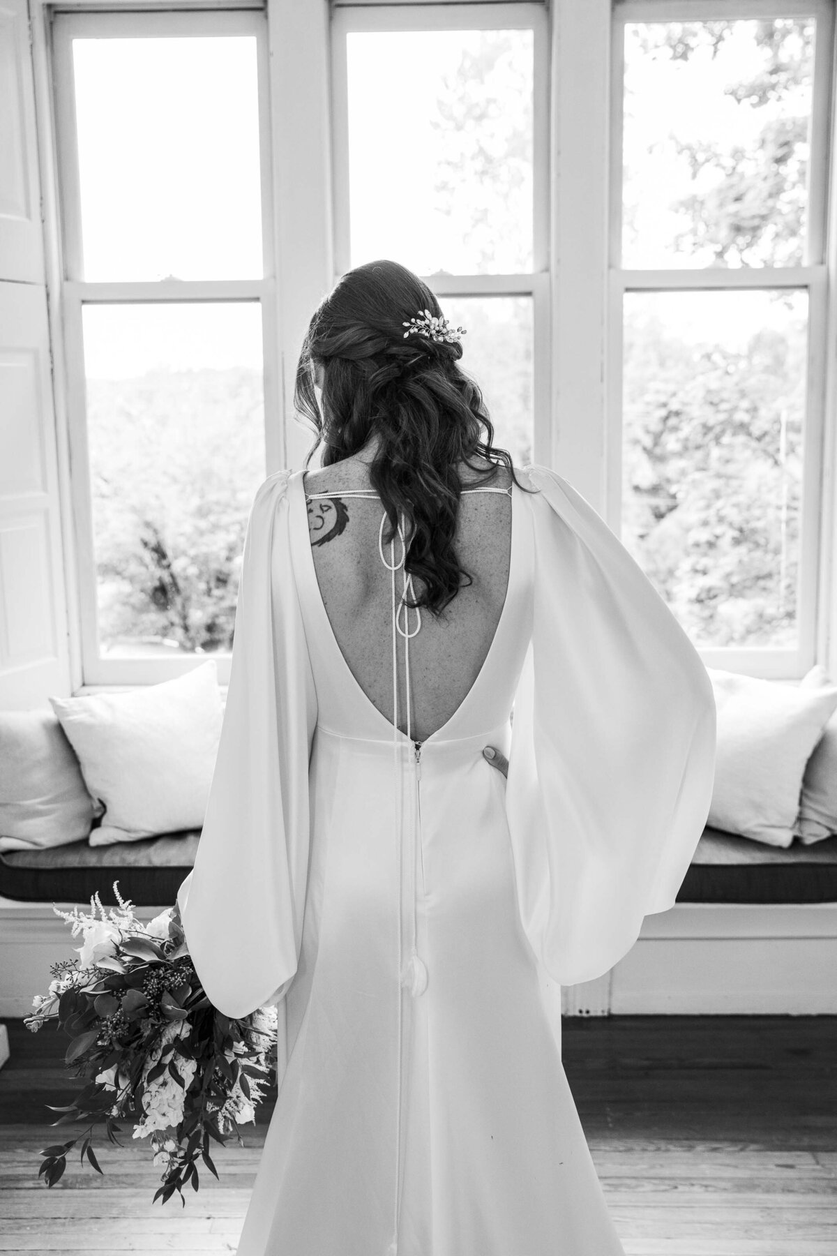 Black and white photo of back of brides dress Duke Sculpture Garden at Dixon Mansion