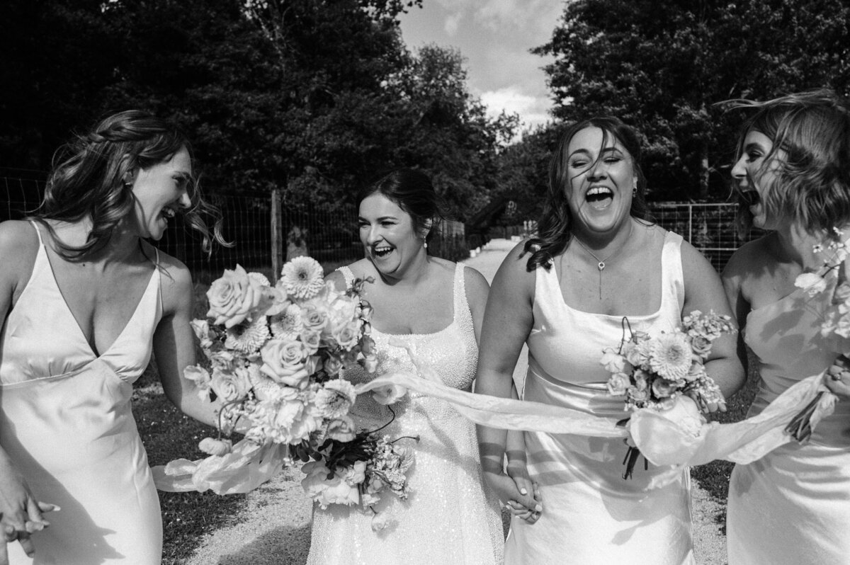 black and white photo of bridesmaids laughing in candid moment at bangor farm in darfield wedding venue