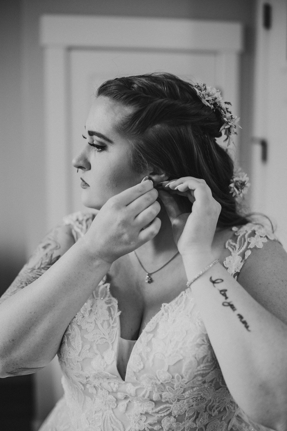 Bride puts on earrings with her tattoo showing important reminder of her partner