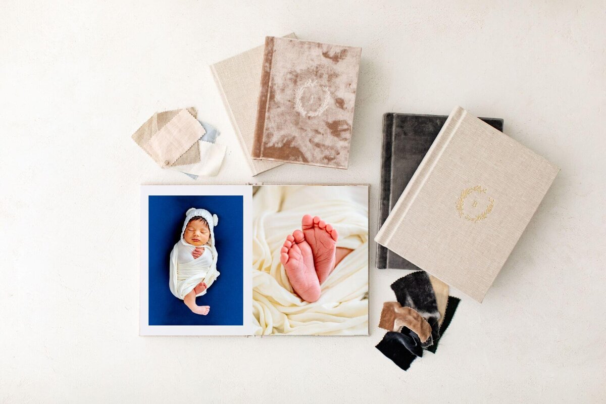 Sample of newborn photo album with images with other albums in various styles and colors near